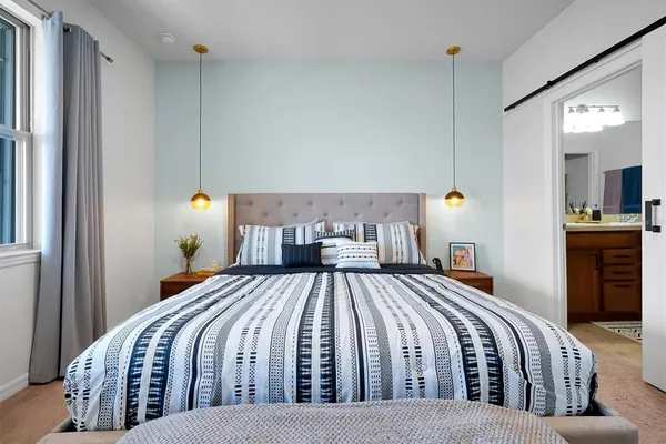 a bedroom with a bed lamps and a couch