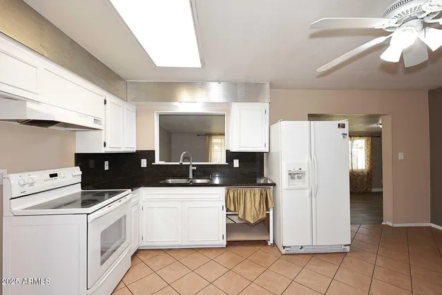 a kitchen with a refrigerator a stove top oven and cabinets