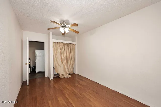 a view of a room with wooden floor and a ceiling fan
