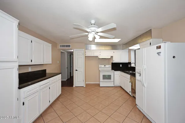 a kitchen with white cabinets and white appliances