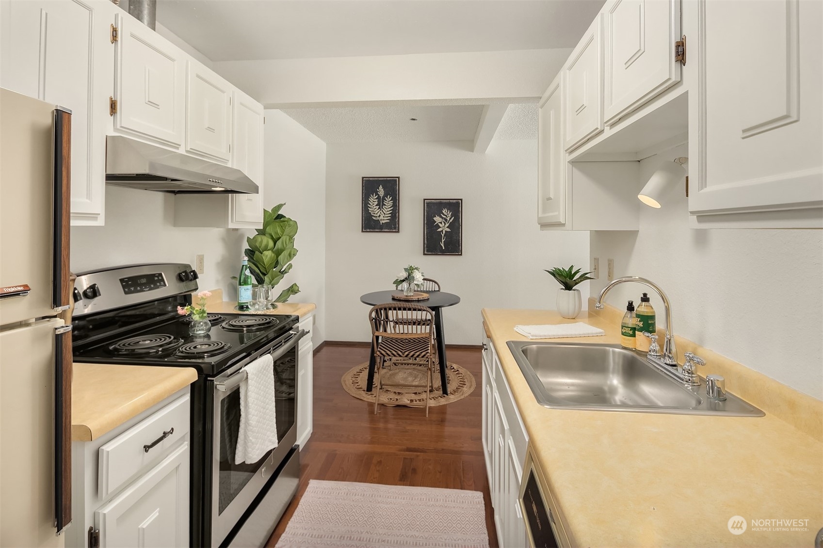 2034 14th Avenue West, Unit 302 Seattle, WA 98119 - Photo 7 of 12 a kitchen with stainless steel appliances granite countertop a sink stove and cabinets