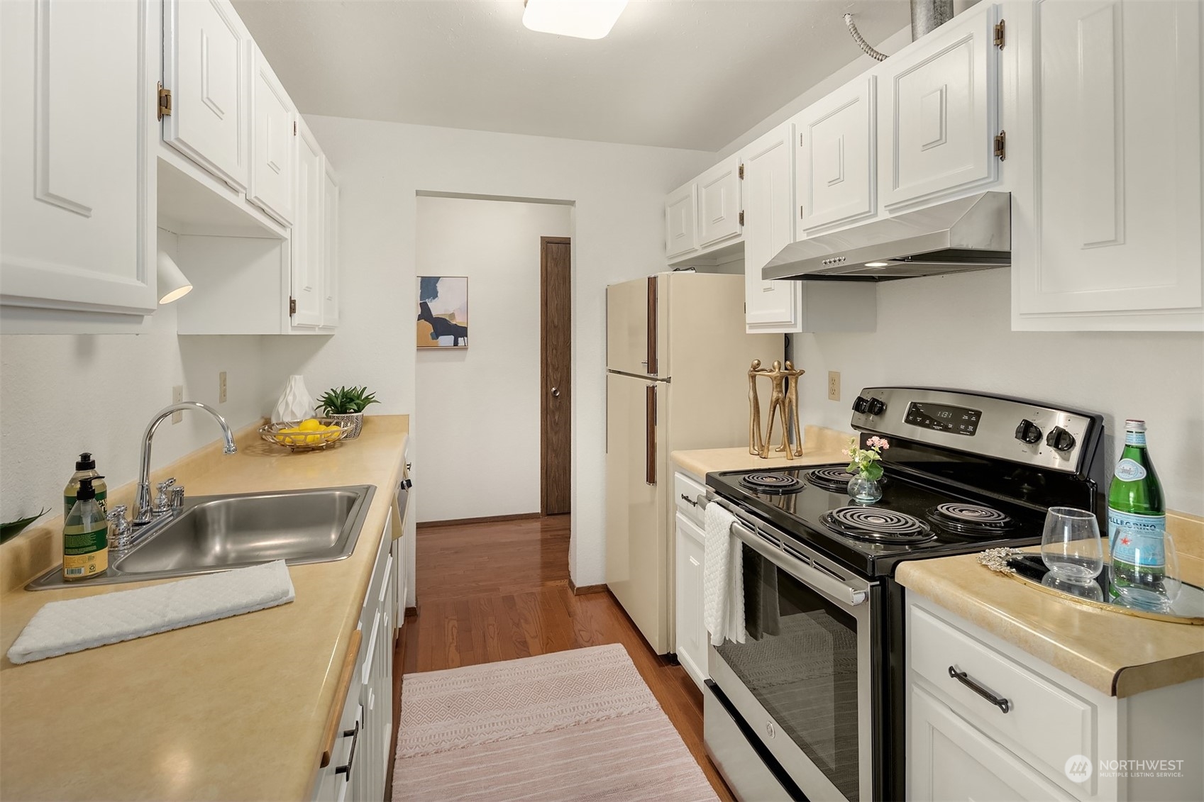 2034 14th Avenue West, Unit 302 Seattle, WA 98119 - Photo 8 of 12 a kitchen with stainless steel appliances granite countertop a sink stove and refrigerator