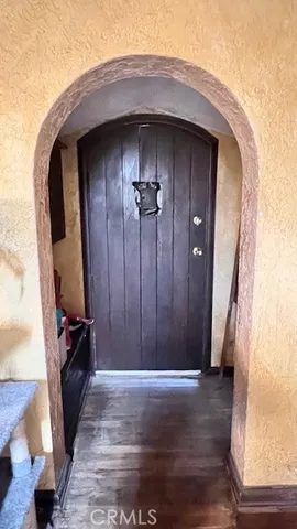 an empty room with wooden floor and hallway