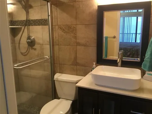 a bathroom with a sink a toilet and shower