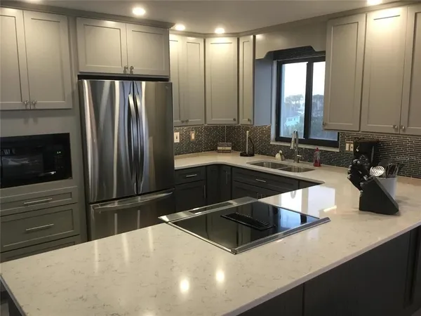 a kitchen with stainless steel appliances a sink a stove and a refrigerator