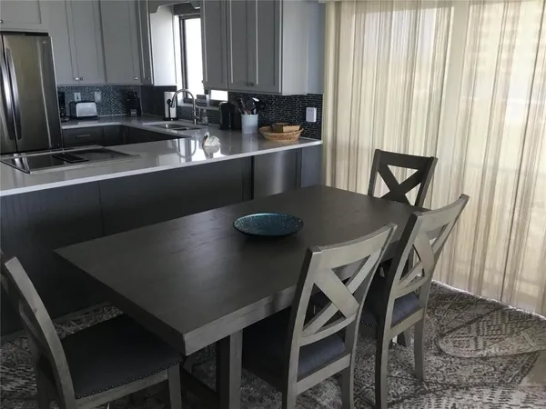 a kitchen with a table chairs sink and cabinets