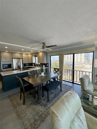 a living room with furniture a table and large windows