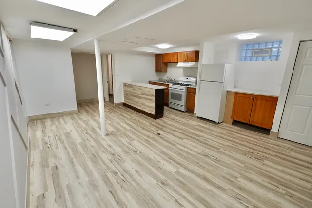 a kitchen view with wooden floor and electronic appliances