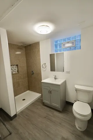 a bathroom with a sink a toilet and shower