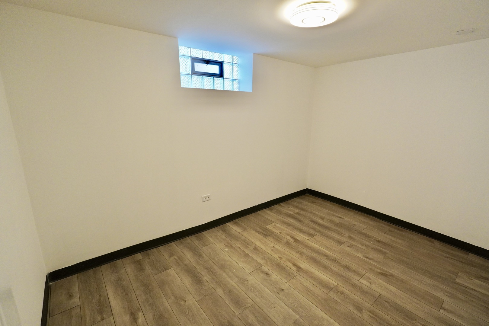 6707 South Artesian Avenue, Unit LL Chicago, IL 60629 - Photo 5 of 15 a view of an empty room with wooden floor and a window