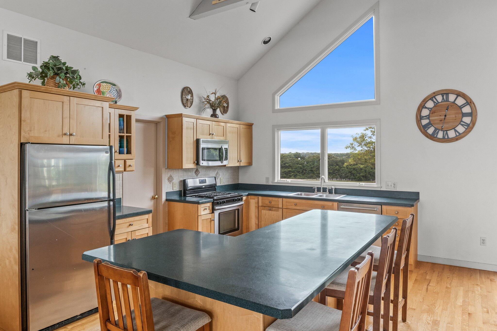 25 Great Hills Road Truro, MA 02666 - Photo 14 of 68 a kitchen with stainless steel appliances granite countertop a sink a stove and a refrigerator