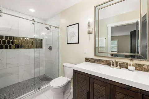 a bathroom with a double vanity sink toilet and shower