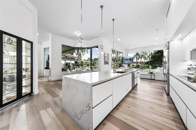 a large kitchen with kitchen island a large counter space a sink appliances and cabinets