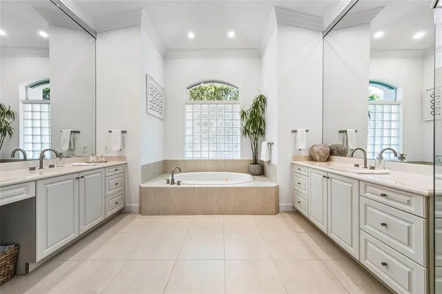a spacious bathroom with a double vanity sink a large mirror and a bathtub