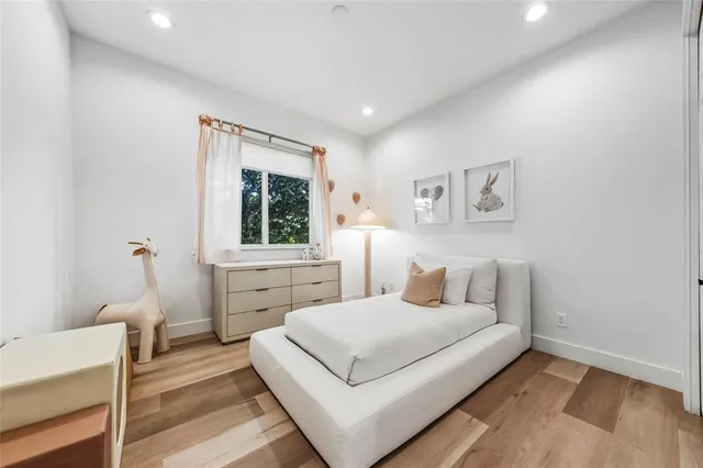 a bedroom with a white bed and a window