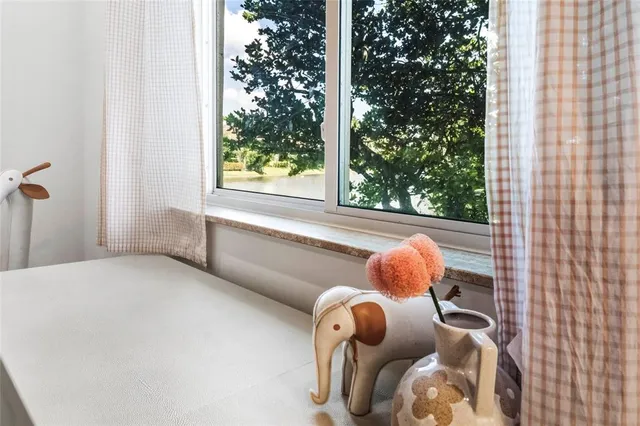 a bathroom with a teddy bear wearing a bathtub and next to a window