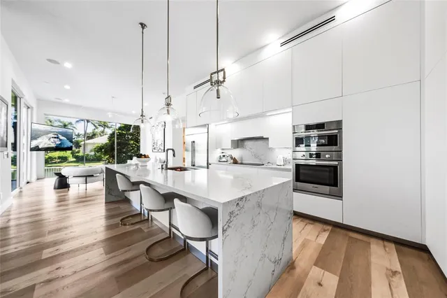 a kitchen with stainless steel appliances kitchen island granite countertop a stove a sink and a refrigerator