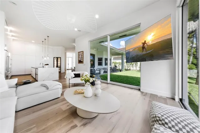 a living room with patio furniture and a wooden floor