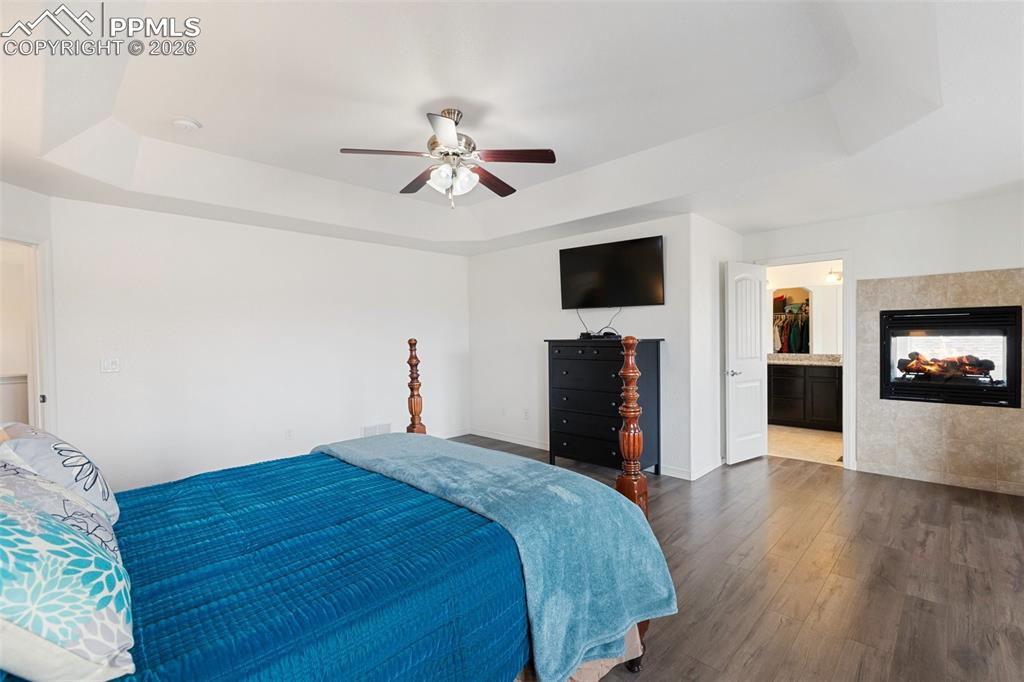 8458 Chasewood Loop Colorado Springs, CO 80908 - Photo 18 of 34 a bed room with a bed a television and wooden floor