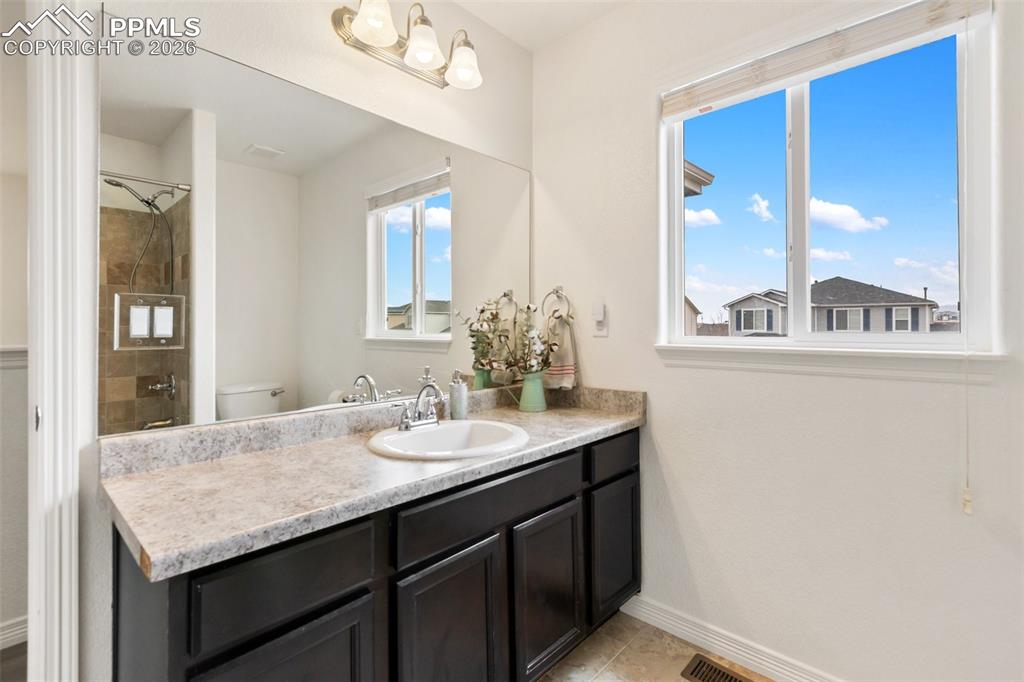 8458 Chasewood Loop Colorado Springs, CO 80908 - Photo 25 of 34 a bathroom with a granite countertop sink and a mirror