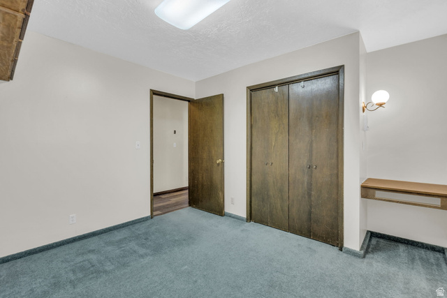 10705 Green Ridge Drive Sandy, UT 84070 - Photo 26 of 55 Unfurnished bedroom featuring carpet flooring, a closet, and a textured ceiling
