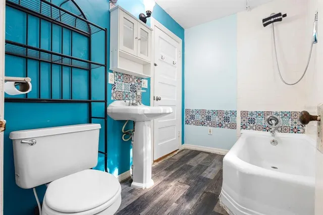 a bathroom with a sink a toilet and shower