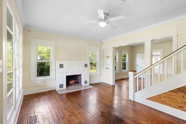 wooden floor fireplace and windows in an empty room
