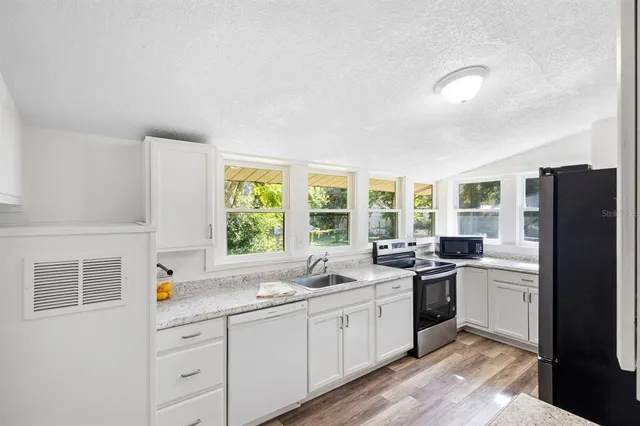 a kitchen with stainless steel appliances a stove a sink and a refrigerator