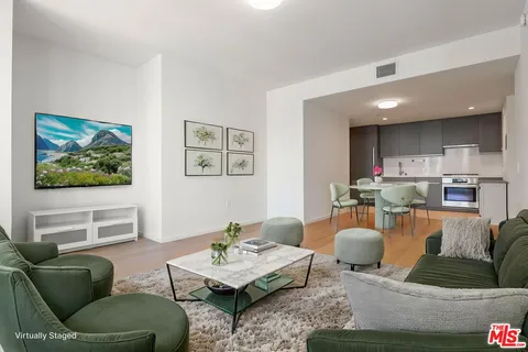 a living room with furniture kitchen view and a table