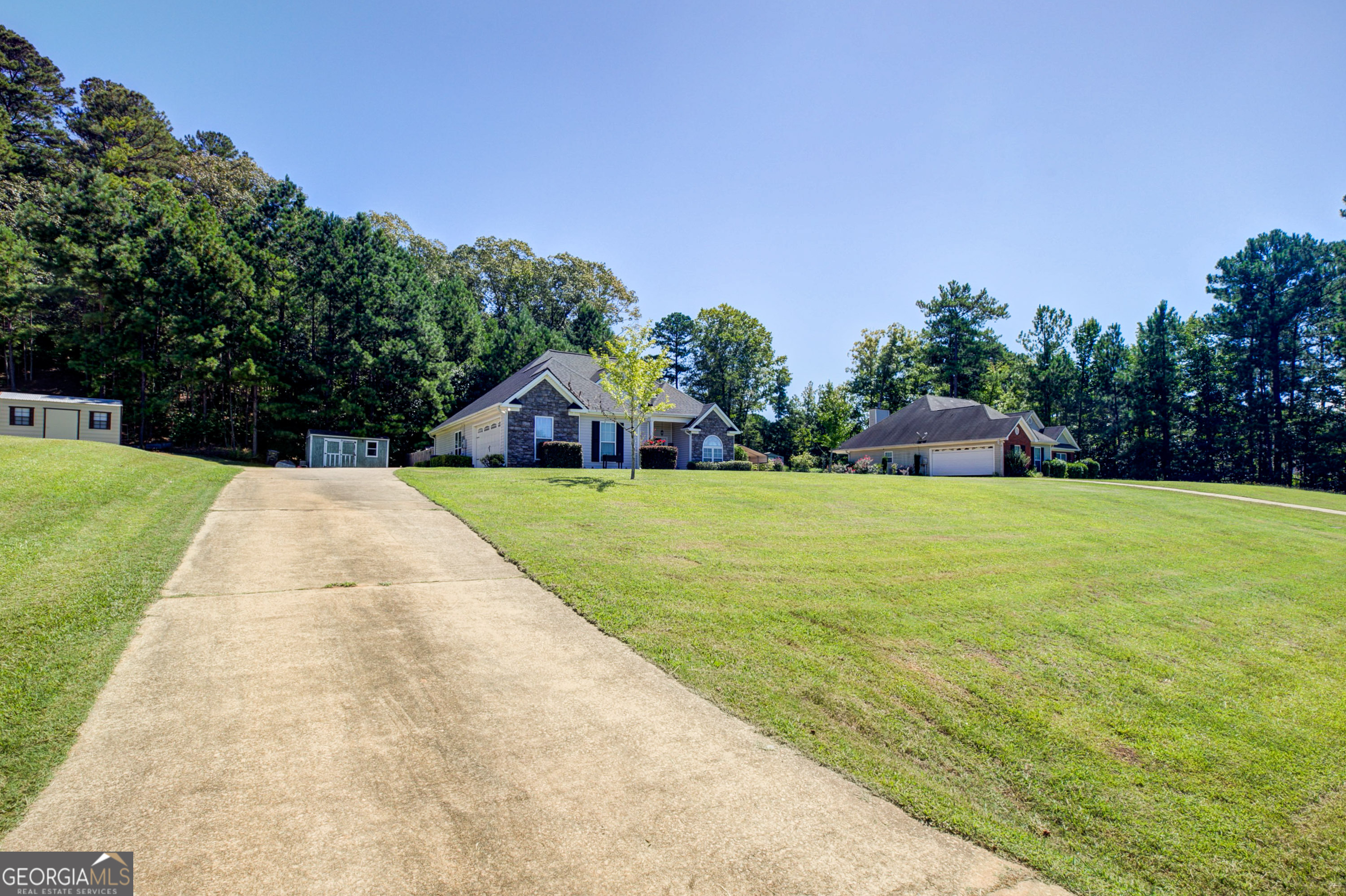 229 John Lovelace Road LaGrange, GA 30241 - Photo 3 of 59 a view of swimming pool that has lawn chairs plants and large trees