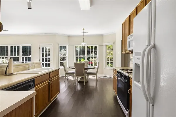 a kitchen with stainless steel appliances granite countertop a refrigerator a stove and a sink