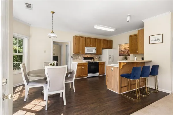 a kitchen with a dining table chairs and white cabinets