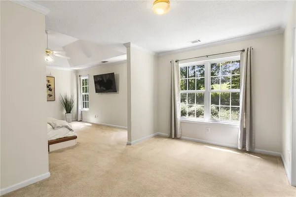 en empty room with windows and ceiling fan