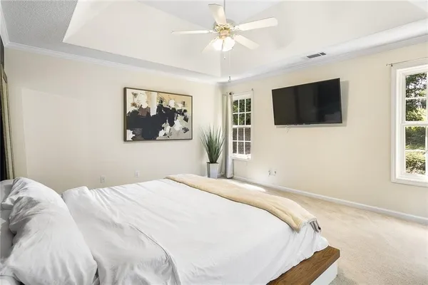 a bedroom with a large bed and a flat screen tv
