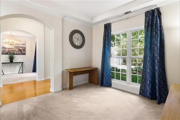 a view of a livingroom with furniture cabinet mirror and a large window
