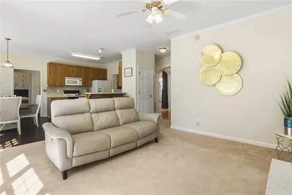 a living room with furniture a mirror and white walls