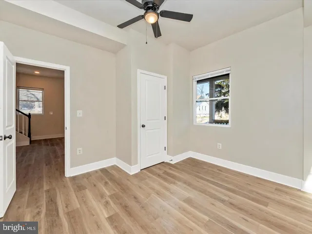 a view of a livingroom with wooden floor and a ceiling fan