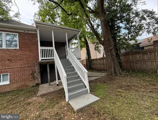 a view of a yard with wooden fence and a large tree