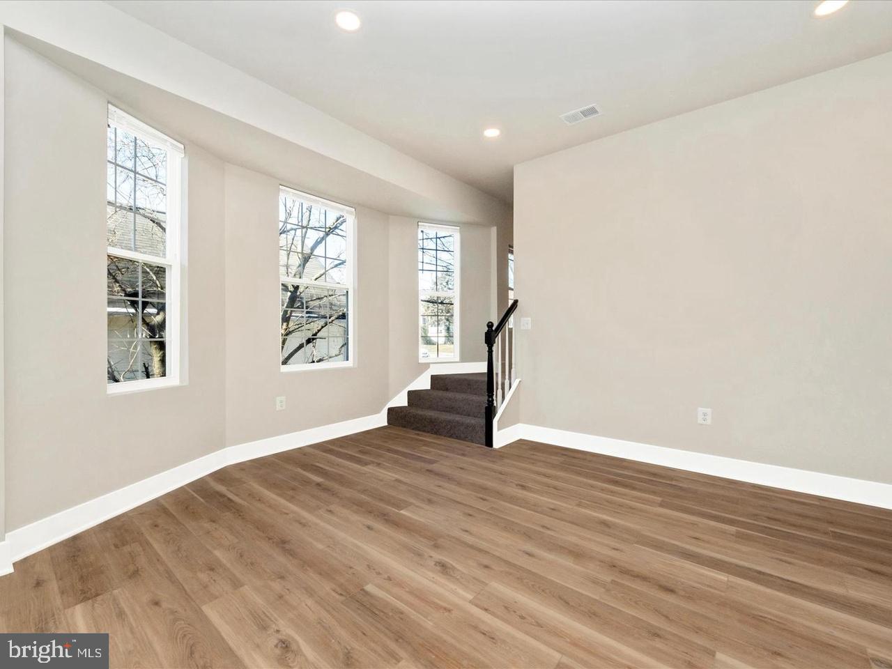 2919 Woodland Avenue Baltimore, MD 21215 - Photo 3 of 25 a view of an empty room with wooden floor and a window