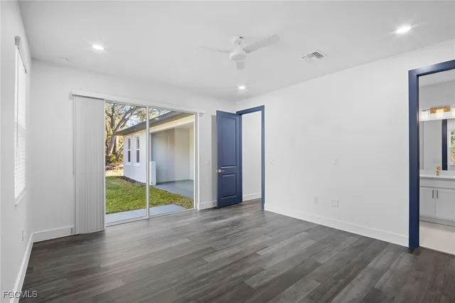 a view of an empty room with wooden floor and closet