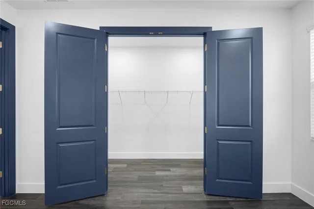 an empty room with wooden floor and closet