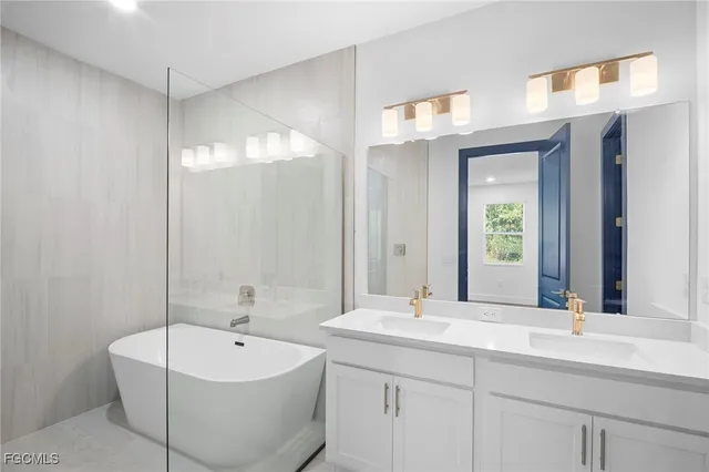 a bathroom with a double vanity sink mirror and bathtub