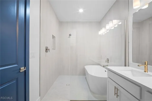 a bathroom with a tub sink and mirror