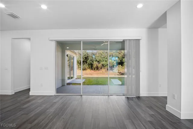 an empty room with wooden floor and a fireplace