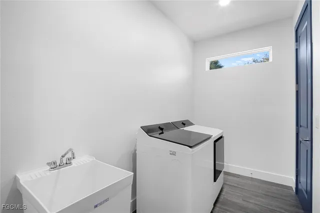 a utility room with wooden floor washer and dryer