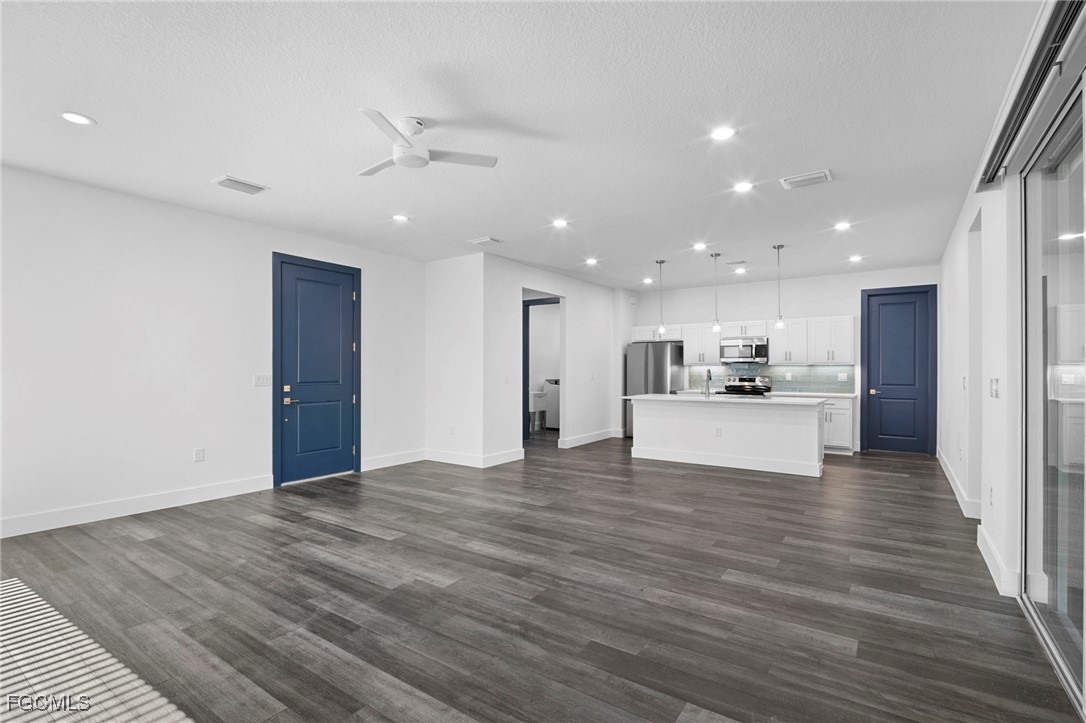 2816 Barry Road North Port, FL 34286 - Photo 6 of 36 a view of an empty room with kitchen view and wooden floor
