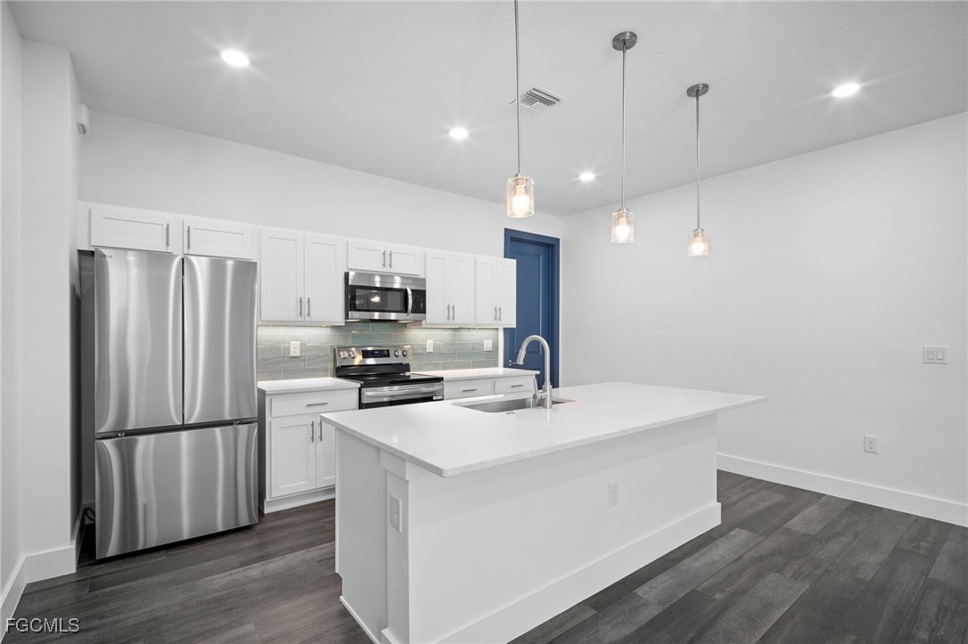 2816 Barry Road North Port, FL 34286 - Photo 8 of 36 a kitchen with stainless steel appliances granite countertop a refrigerator a sink dishwasher a stove and a refrigerator with wooden floor