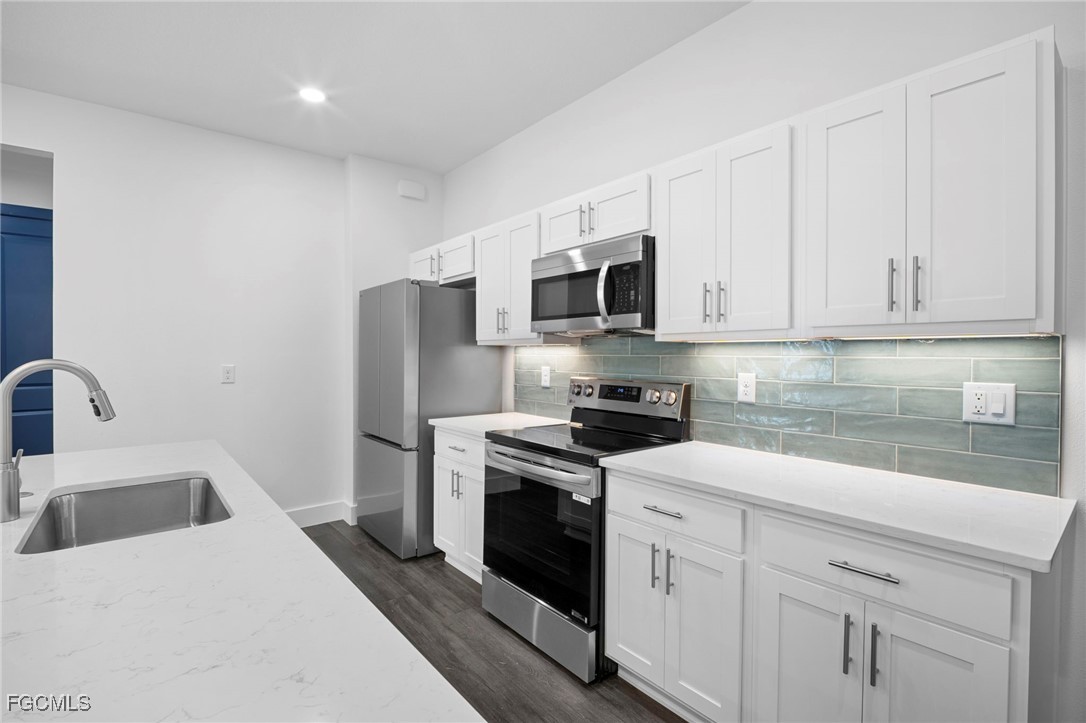 2816 Barry Road North Port, FL 34286 - Photo 10 of 36 a kitchen with white cabinets stainless steel appliances and sink