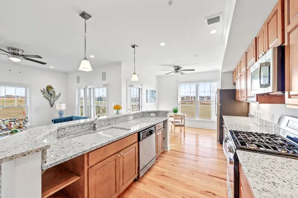 a kitchen with granite countertop a sink stove and cabinets