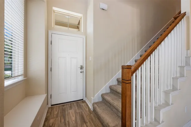 a view of a hallway with wooden floor and staircase